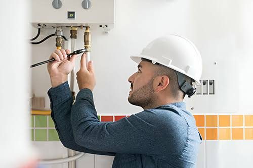 Técnico reparando un calentador de gas